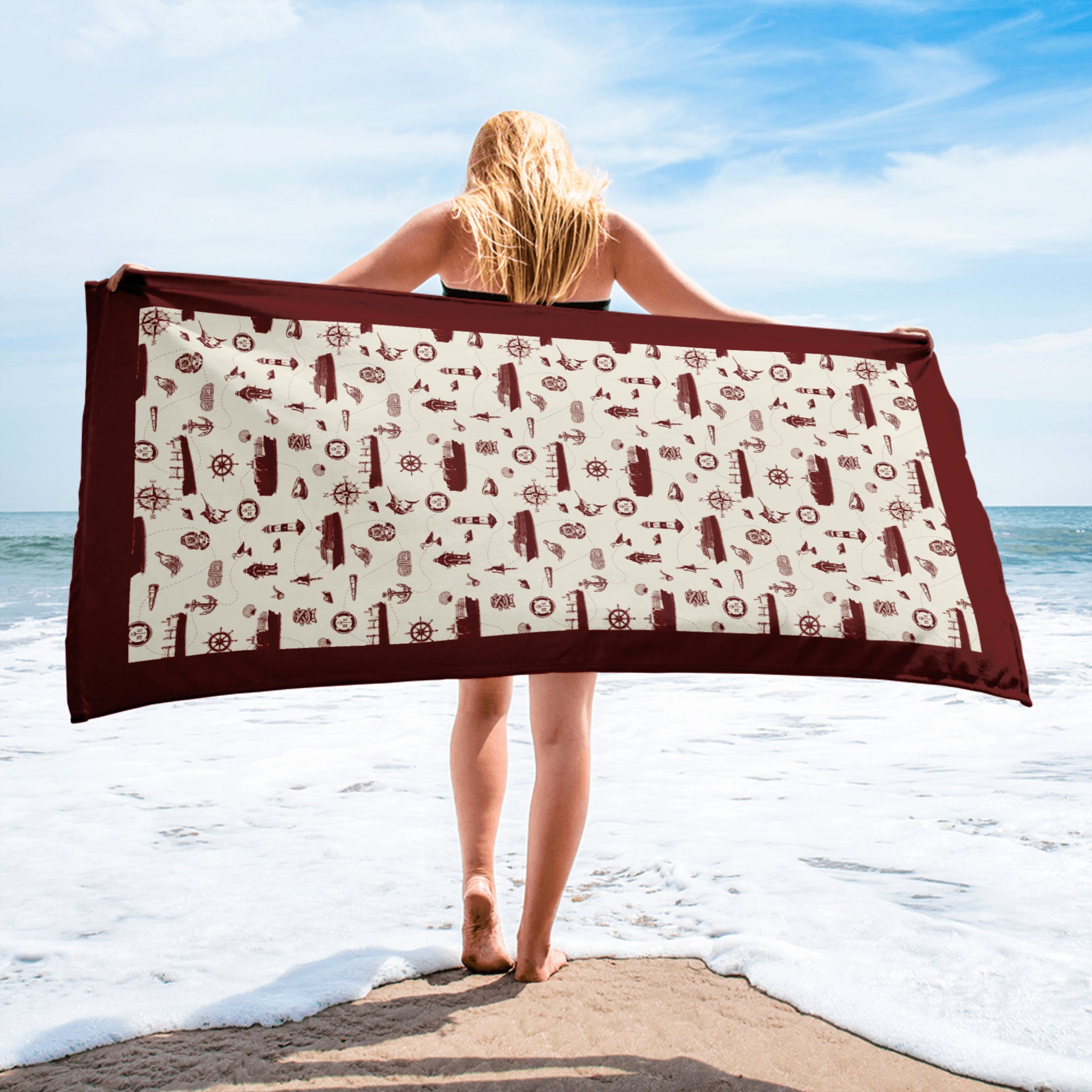 Person holding a beach towel with a pattern on a beach from shore leave Main image