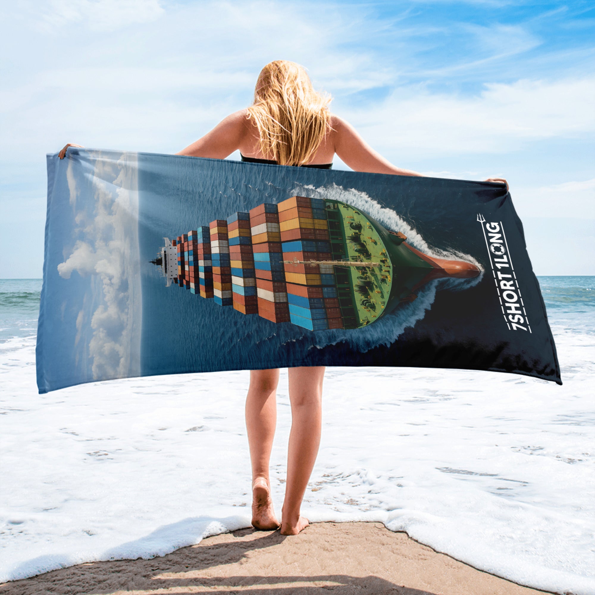 Crew is holding a beach towel with a colorful ship design on a beach