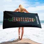 Crew is holding a beach towel with a container ship design on a beach
