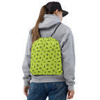 Person wearing a gray hoodie and blue jeans with a bright Lemon excursion bag featuring black maritime patterns on a white background.